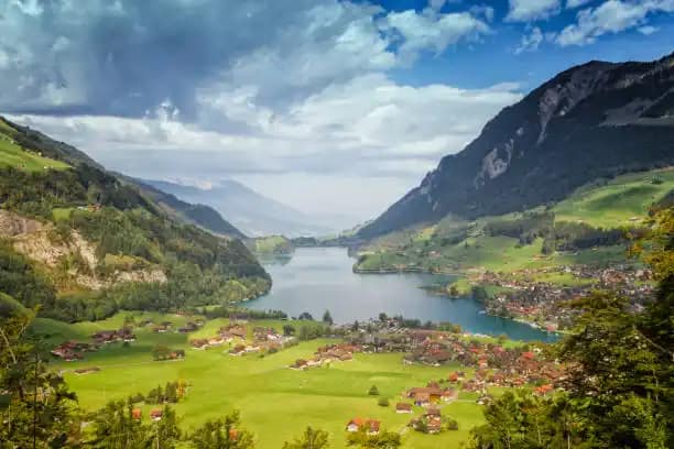 Explore Eswatini: 12 Astonishing Facts About Africa's Hidden Kingdom - Travel Guide 6 Panoramic view of a Swiss valley with a lake, rolling green hills, and mountain peaks.